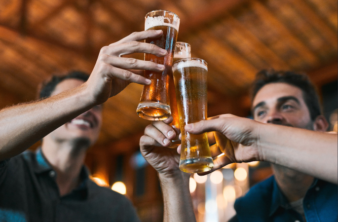 Three men clinking their beer glasses together